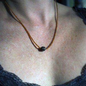 Amber-colored bead necklace with silver charm